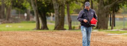 Ethan Weibrecht tossing seed on the pollinator plot.
